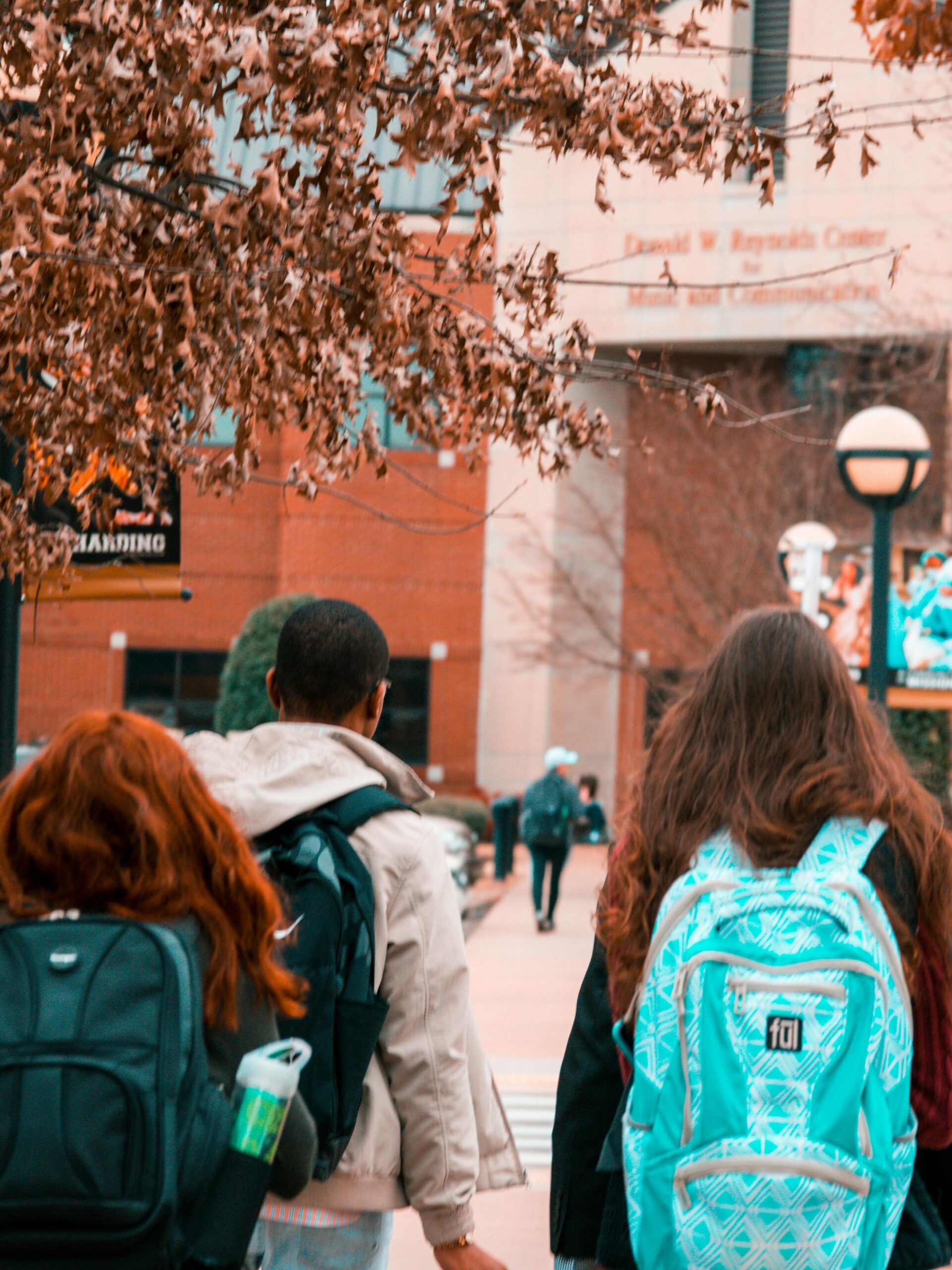 A group of college students with backpacks walking together outdoors on campus.
